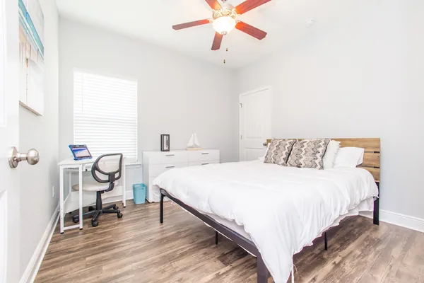 Bedroom with a queen bed, work desk and ceiling fan