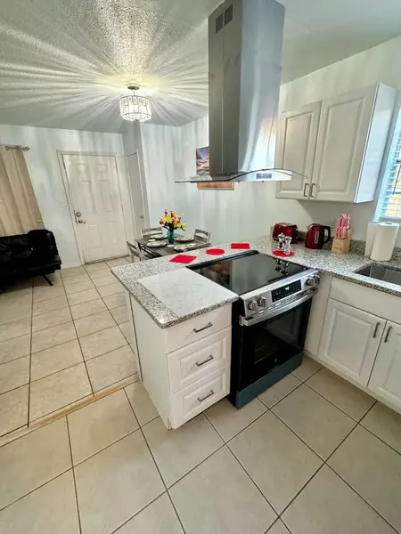Kitchen with a range hood and electric stove