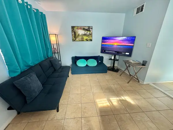 Living area with a teal sofa and a large TV