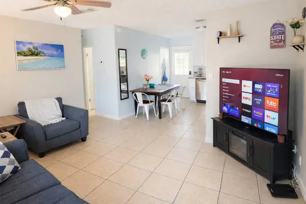Living area with a TV and the dining table behind