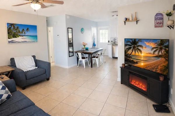 Open living and dining area with a sofa, TV and electric fireplace