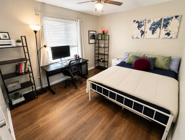 Second bedroom with a full bed, desk and map wall art